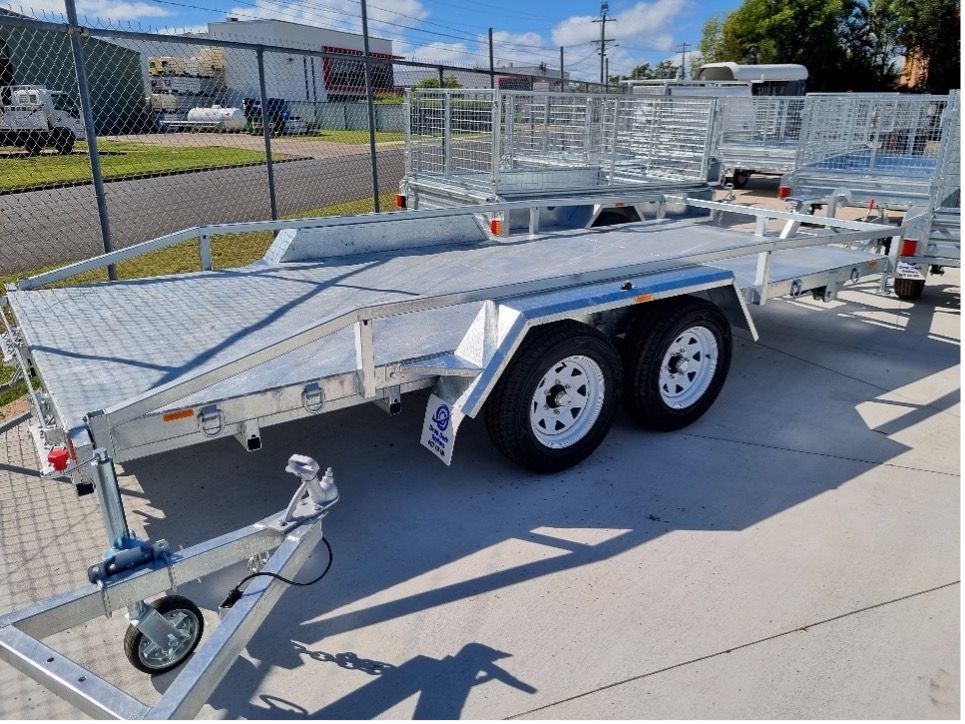 A Trailer is Parked on the Side of the Road Next to a Chain Link Fence — Drop Deck Trailers In Urangan QLD