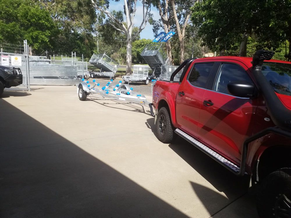 Red Pick Up Vehicle With Boat Trailer — Drop Deck Trailers In Hervey Bay QLD