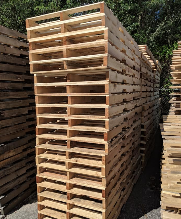 Stacked wooden pallets—learn how to turn pallets into profit with The Simplest Biz Training.