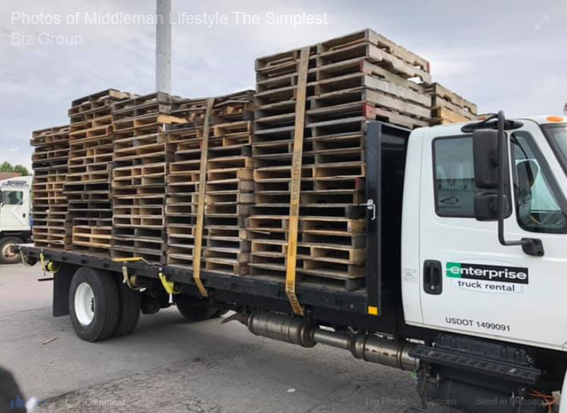 A white enterprise truck is loaded with wooden pallets.  Pallet student from the simplest biz