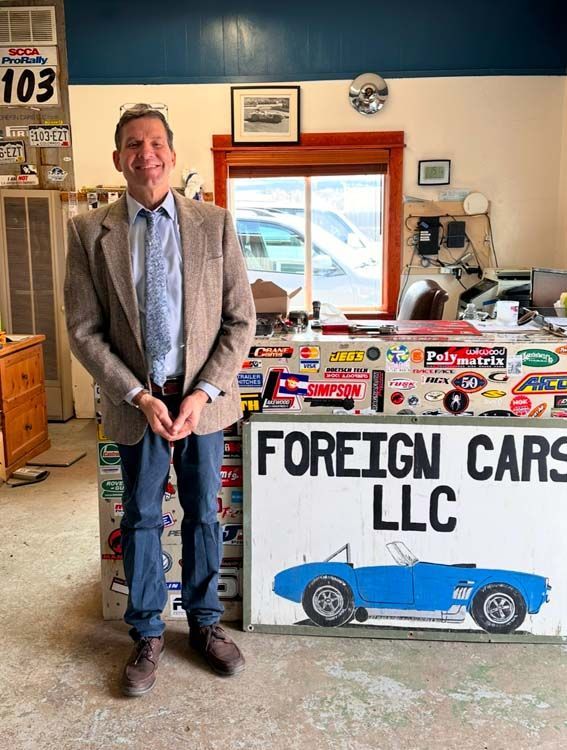 Man in blazer stands in front of 