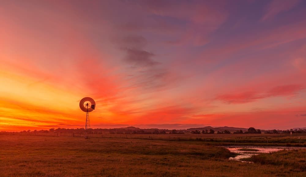 A Windmill in the Middle of a Field at Sunset — Roof Restoration Masters In Aberglasslyn, NSW