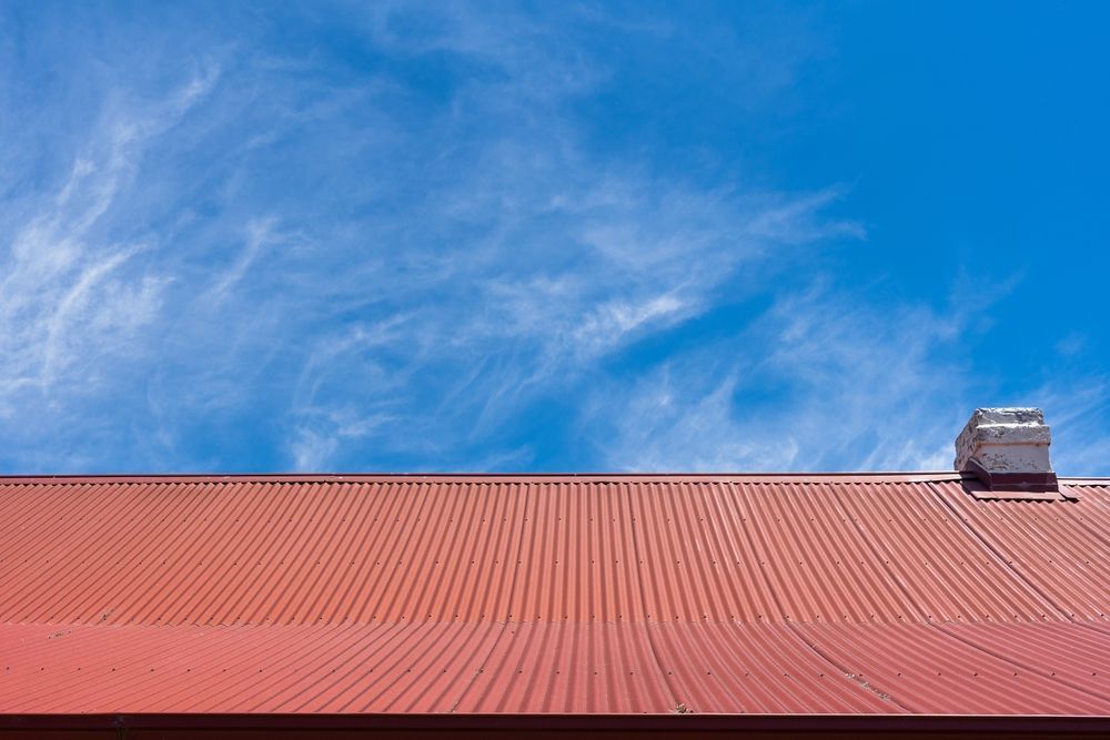 A Red Roof With a Chimney on Top of It — Roof Restoration Masters In Charlestown, NSW