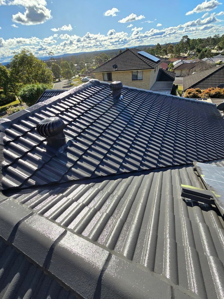 A Close Up of a Roof of a House With a Blue Sky in the Background — Roof Restoration Masters In Toukley, NSW