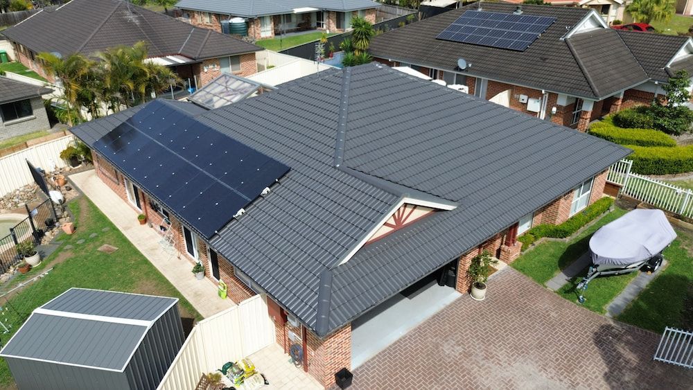 An Aerial View of a House With Solar Panels on the Roof — Roof Restoration Masters In Wadalba, NSW