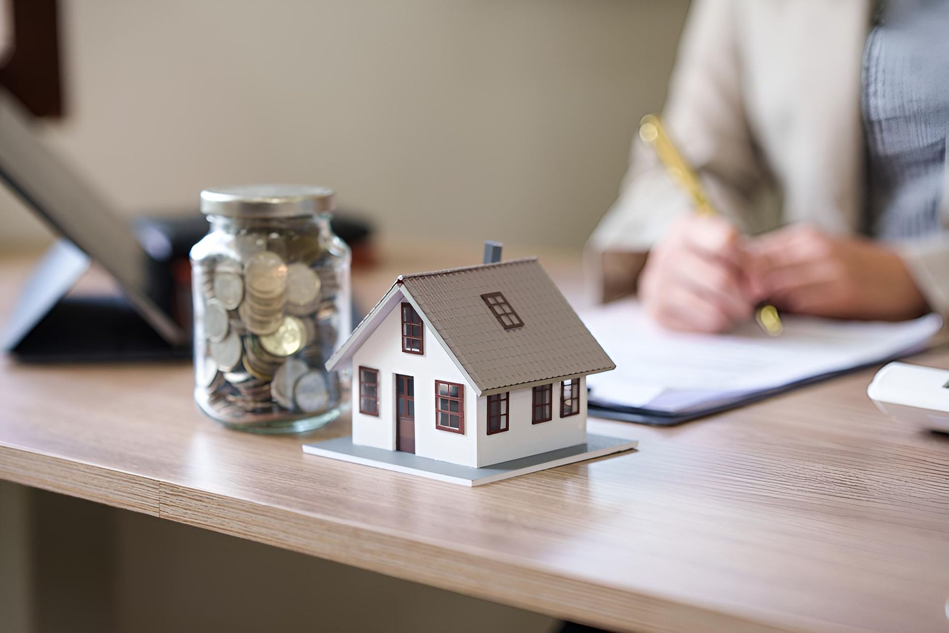 A Model House Is Sitting On A Desk — Angel Conveyancing In Larrakeyah, NT