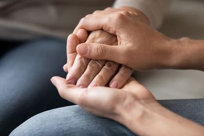 A close up of a person holding another person 's hand.