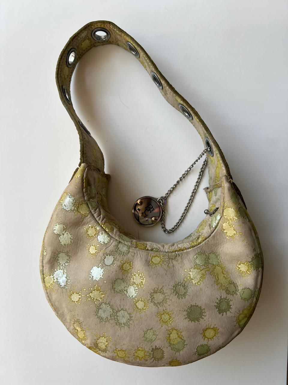 Bolso de hombro pequeño de color beige con estampado de salpicaduras metálicas doradas