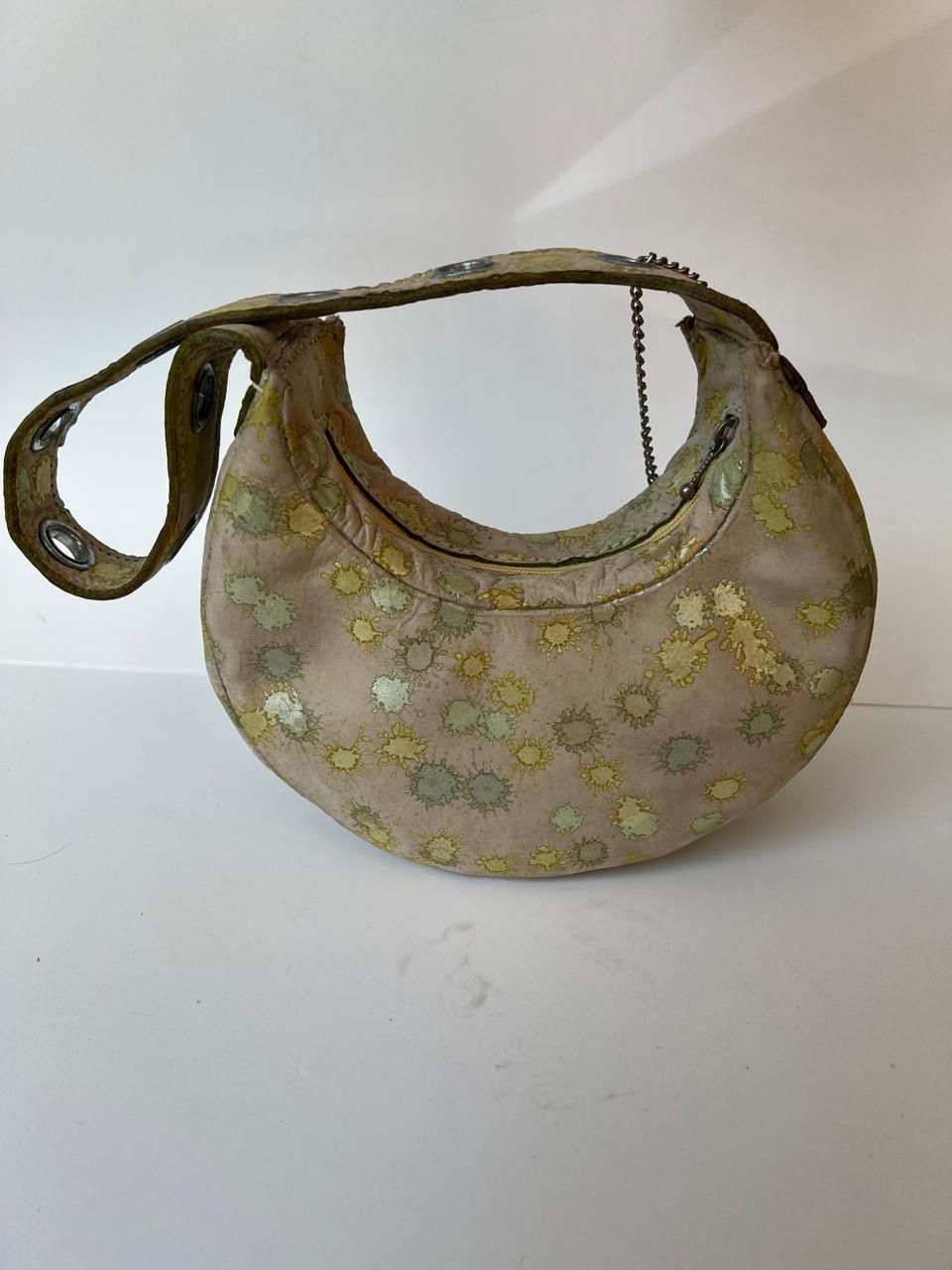 Bolso de hombro pequeño de color beige con estampado de salpicaduras metálicas doradas