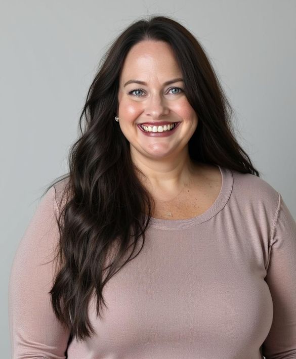 A woman with long hair is smiling and wearing a pink shirt