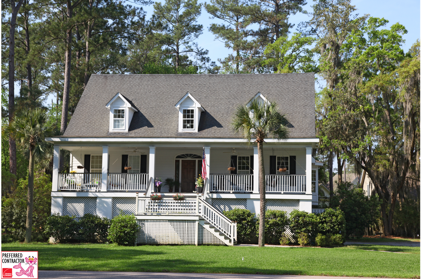 A large white house with a gray roof and a large porch