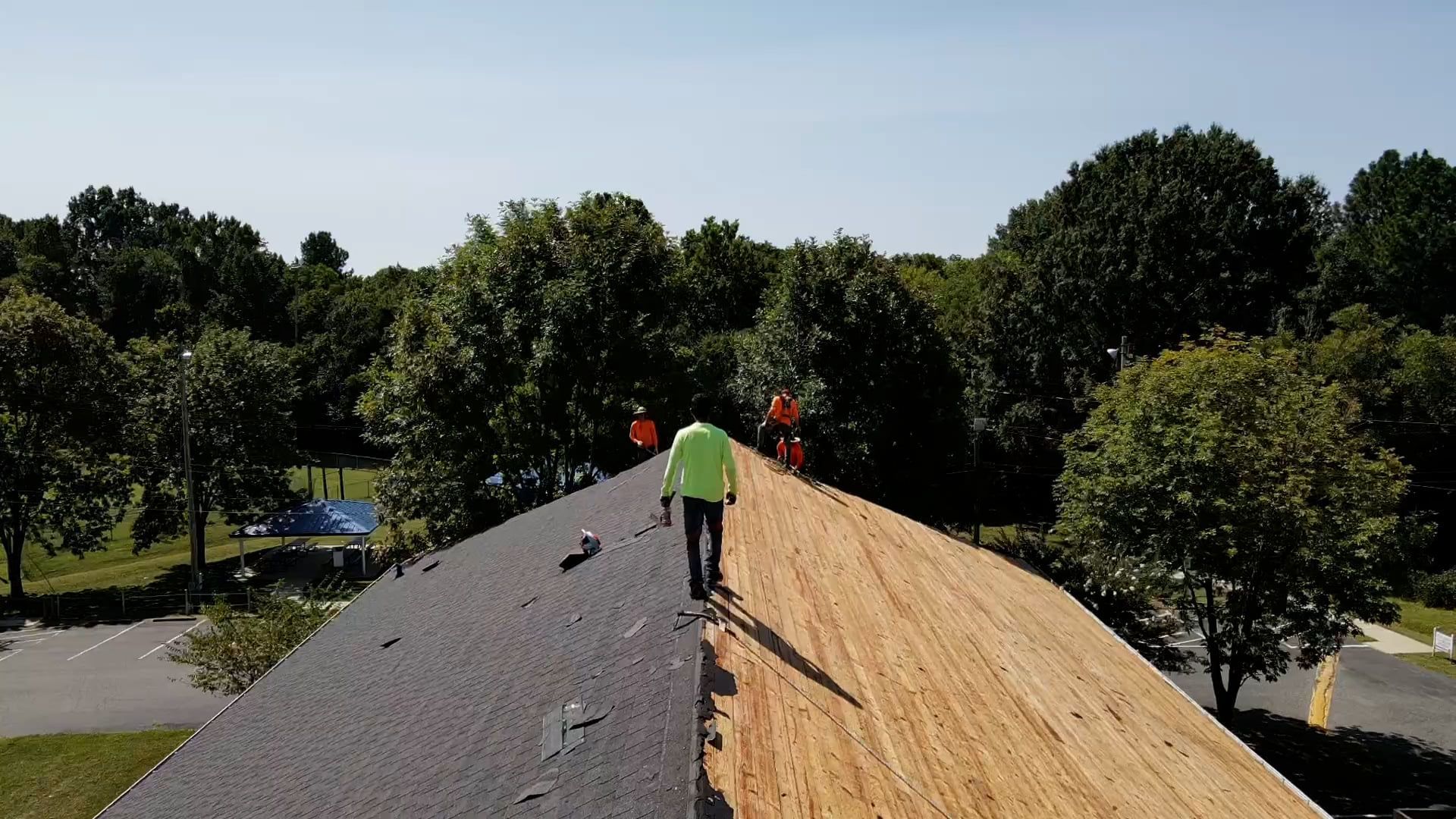 contractor walking across center of a roofs peek during roof replacement project