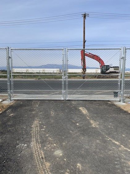 A Chain Link Fence with A Red Excavator in The Background — Nuevo, CA — Golden West Fence