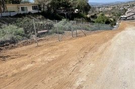 A Dirt Road with A Chain Link Fence on The Side of It — Nuevo, CA — Golden West Fence