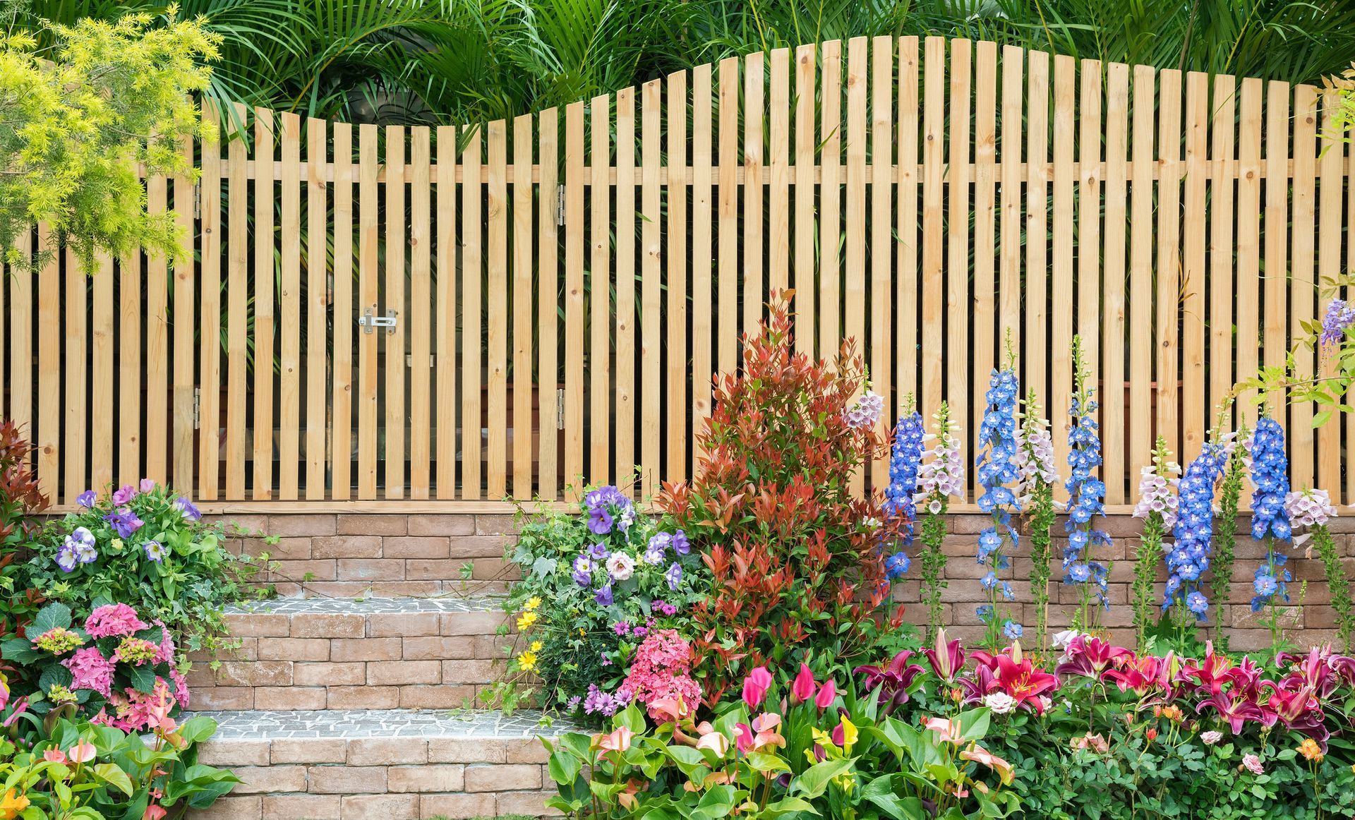 A Wooden Fence Surrounds a Garden Filled with Flowers — Nuevo, CA — Golden West Fence