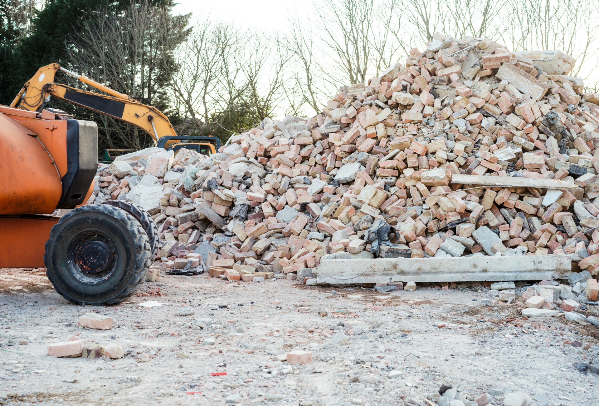 A pile of bricks is sitting on the ground next to a bulldozer.