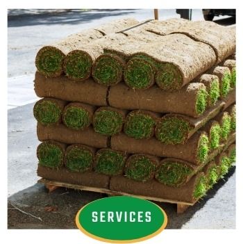 Stacked rolls of sod with a green “SERVICES” sign at the bottom