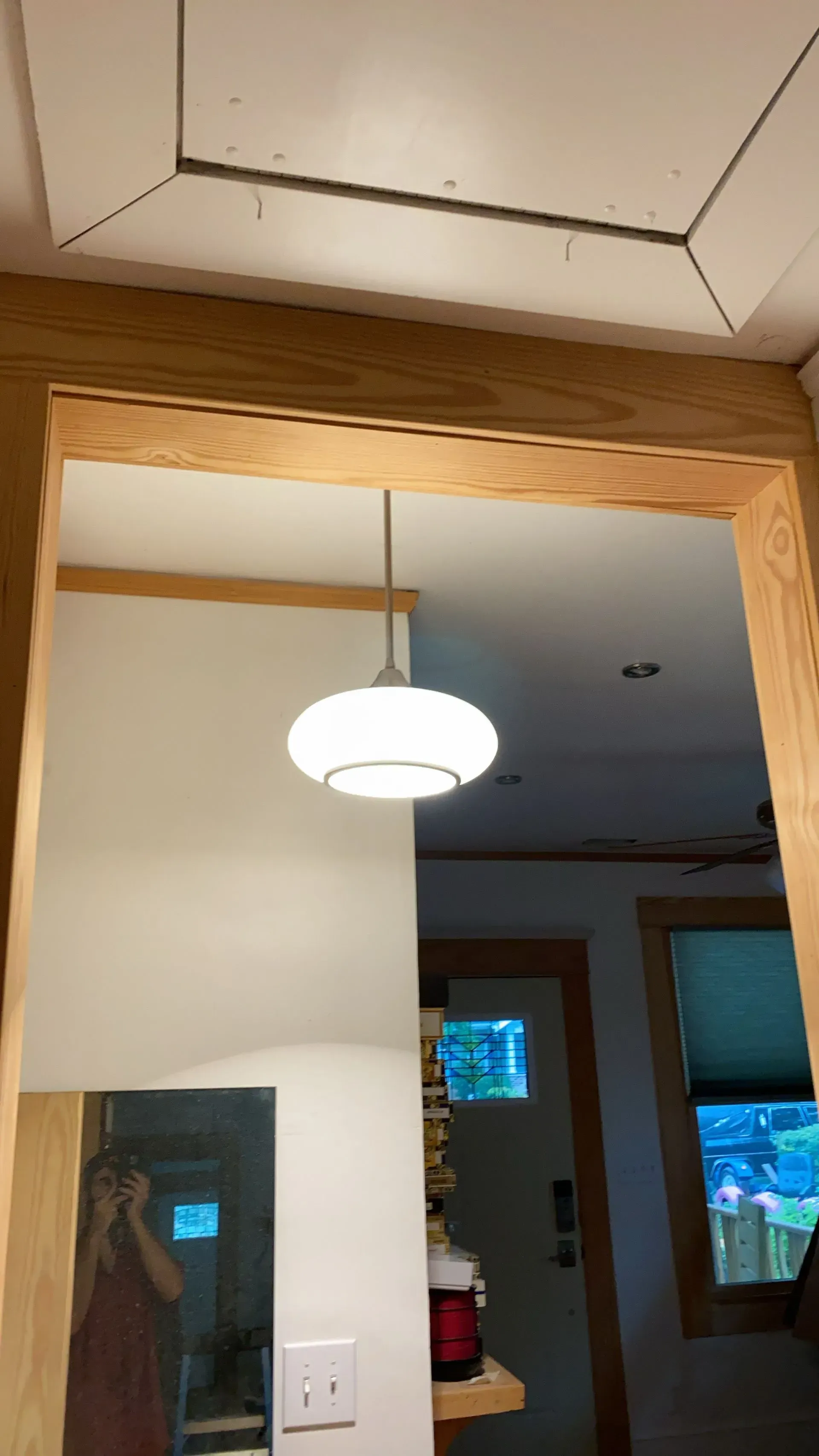 Interior view through a doorway with a pendant light fixture. Light wood trim surrounds the opening.
