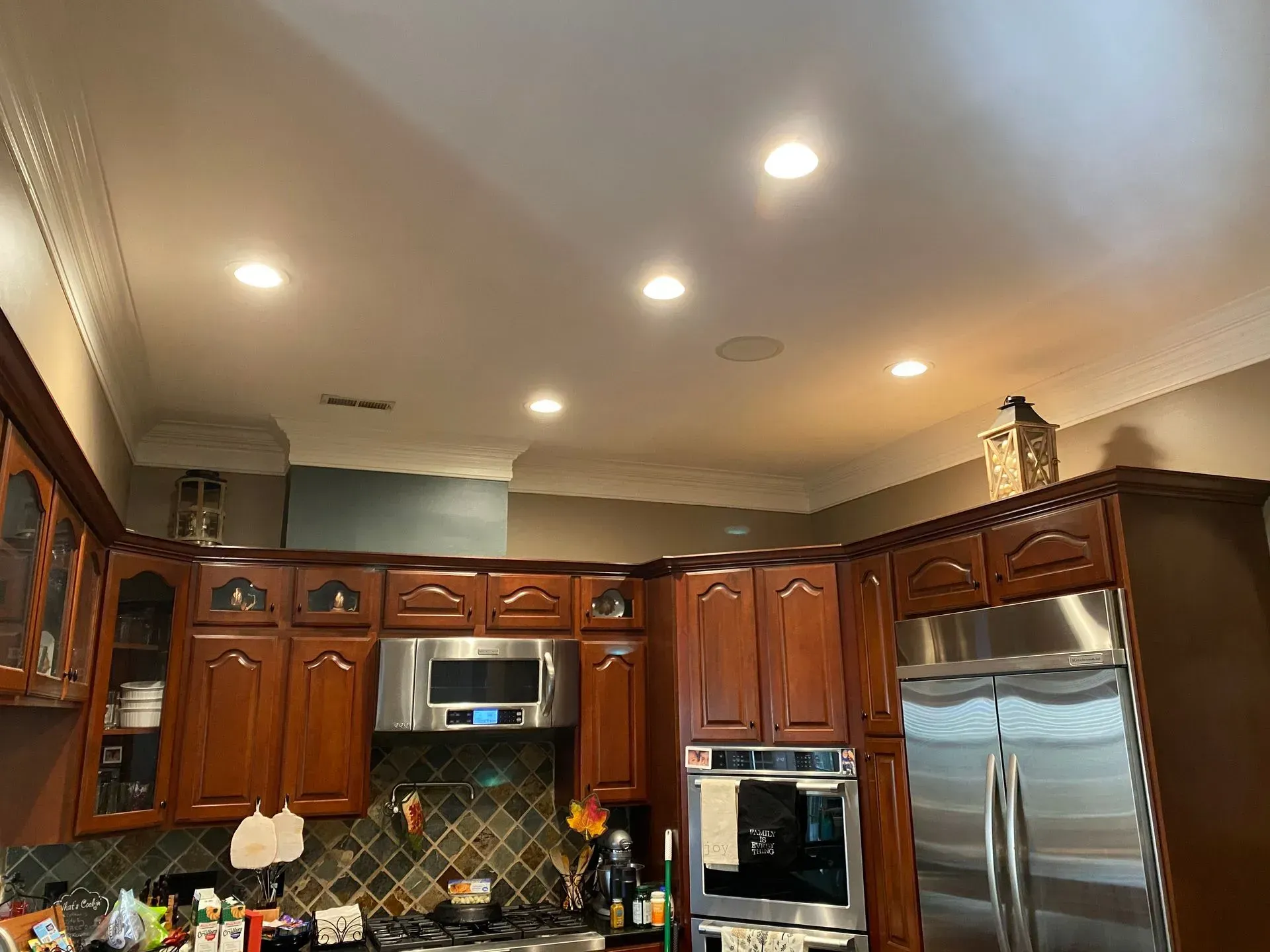 Kitchen with brown cabinets, stainless steel appliances, and recessed ceiling lights.