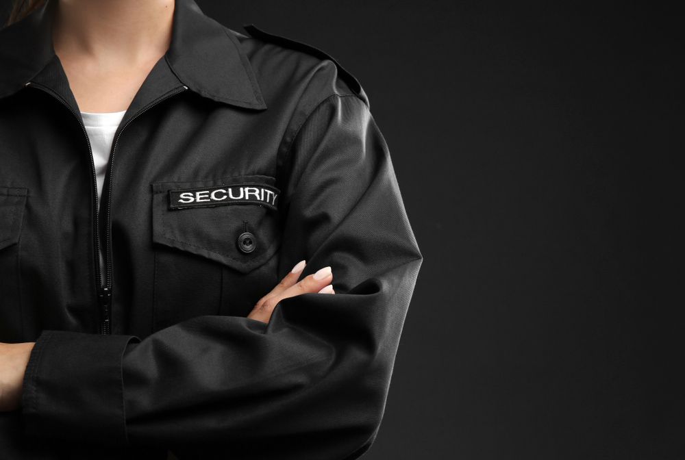 A Woman In A Black Security Uniform Has Her Arms Crossed — Professional Security Guards in Blackwater, QLD