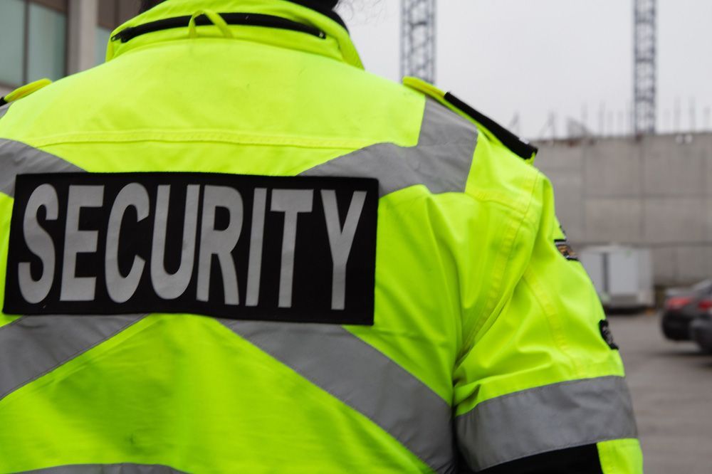 A Security Guard Wearing A Bright Yellow Jacket Has A Security Patch On His Back — Professional Security Guards in Toowoomba, QLD