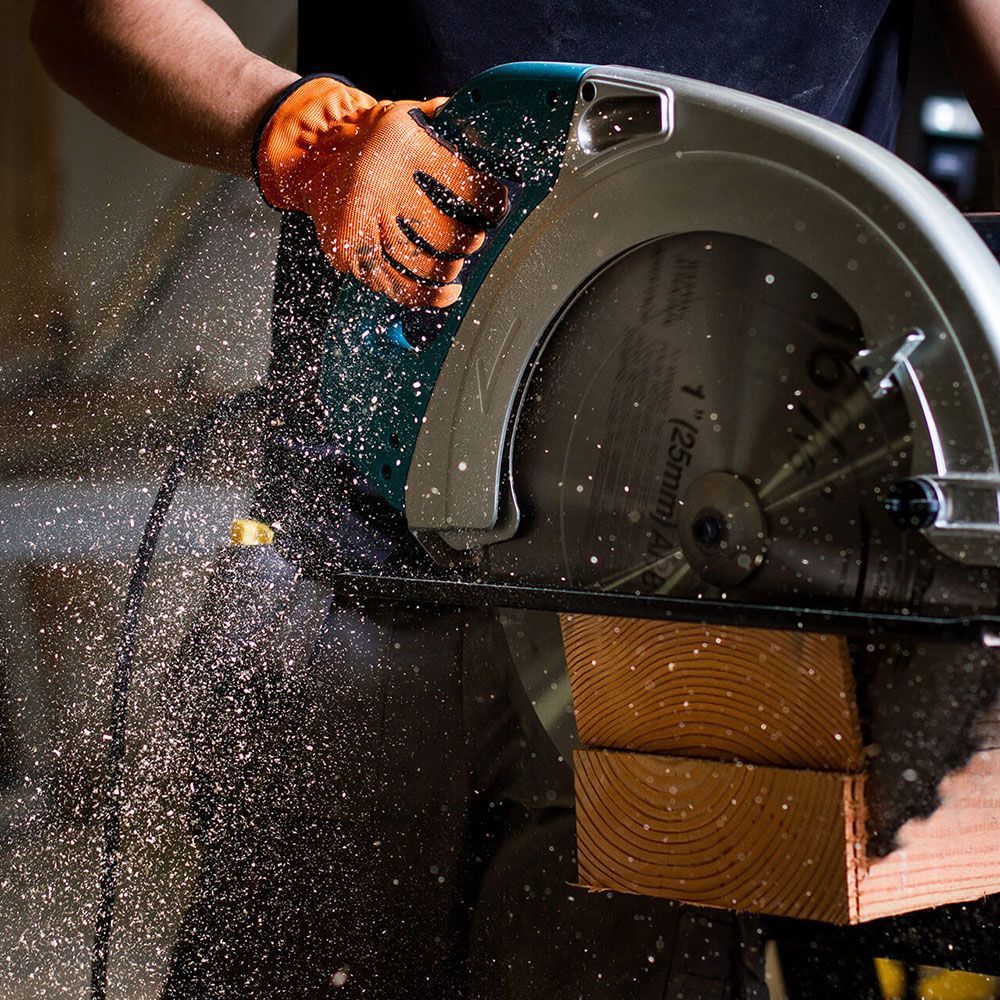 A person is using a circular saw to cut a piece of wood