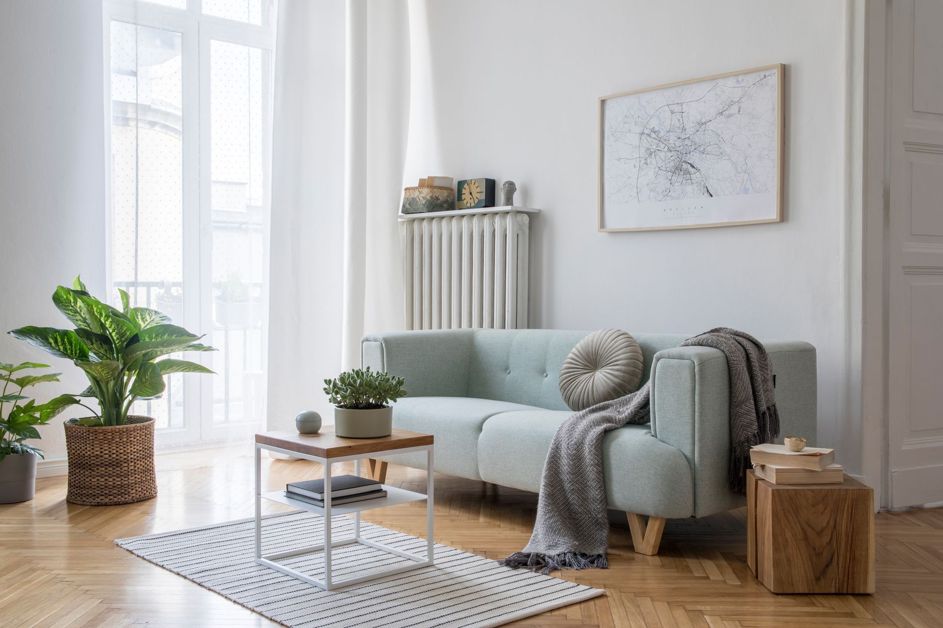 A living room with a couch , coffee table , rug and plants.