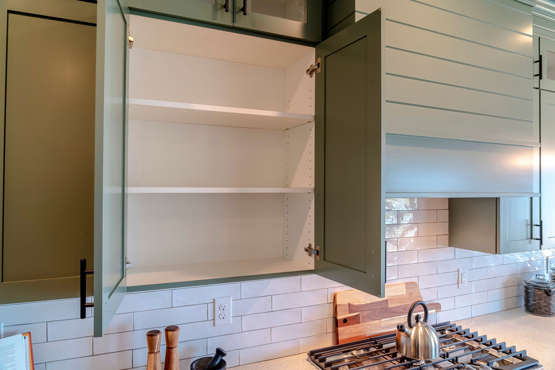 An empty cabinet in a kitchen with the door open.