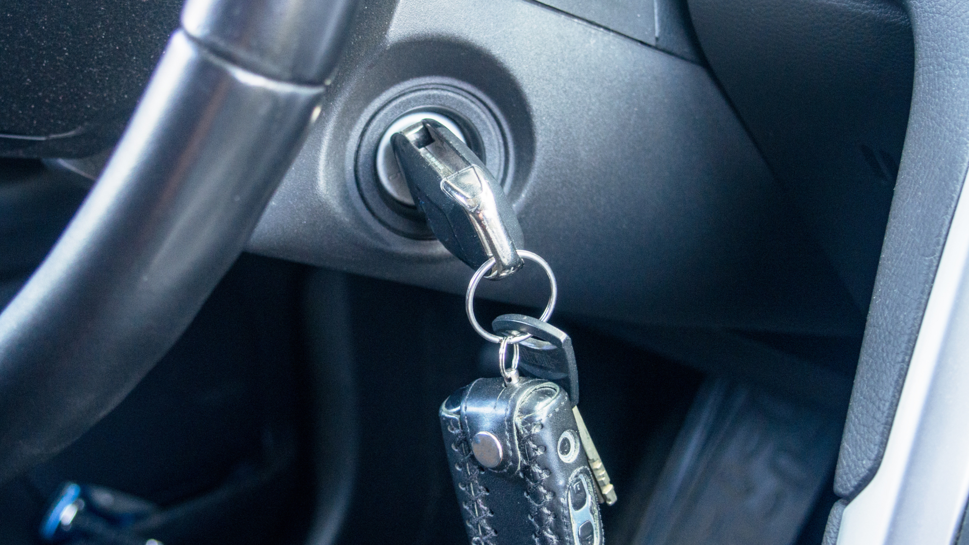 A car key is sitting in the ignition of a car.