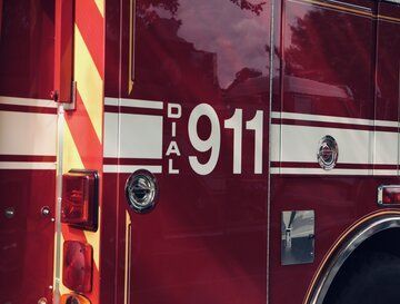 A red fire truck with the number 911 on the side of it.
