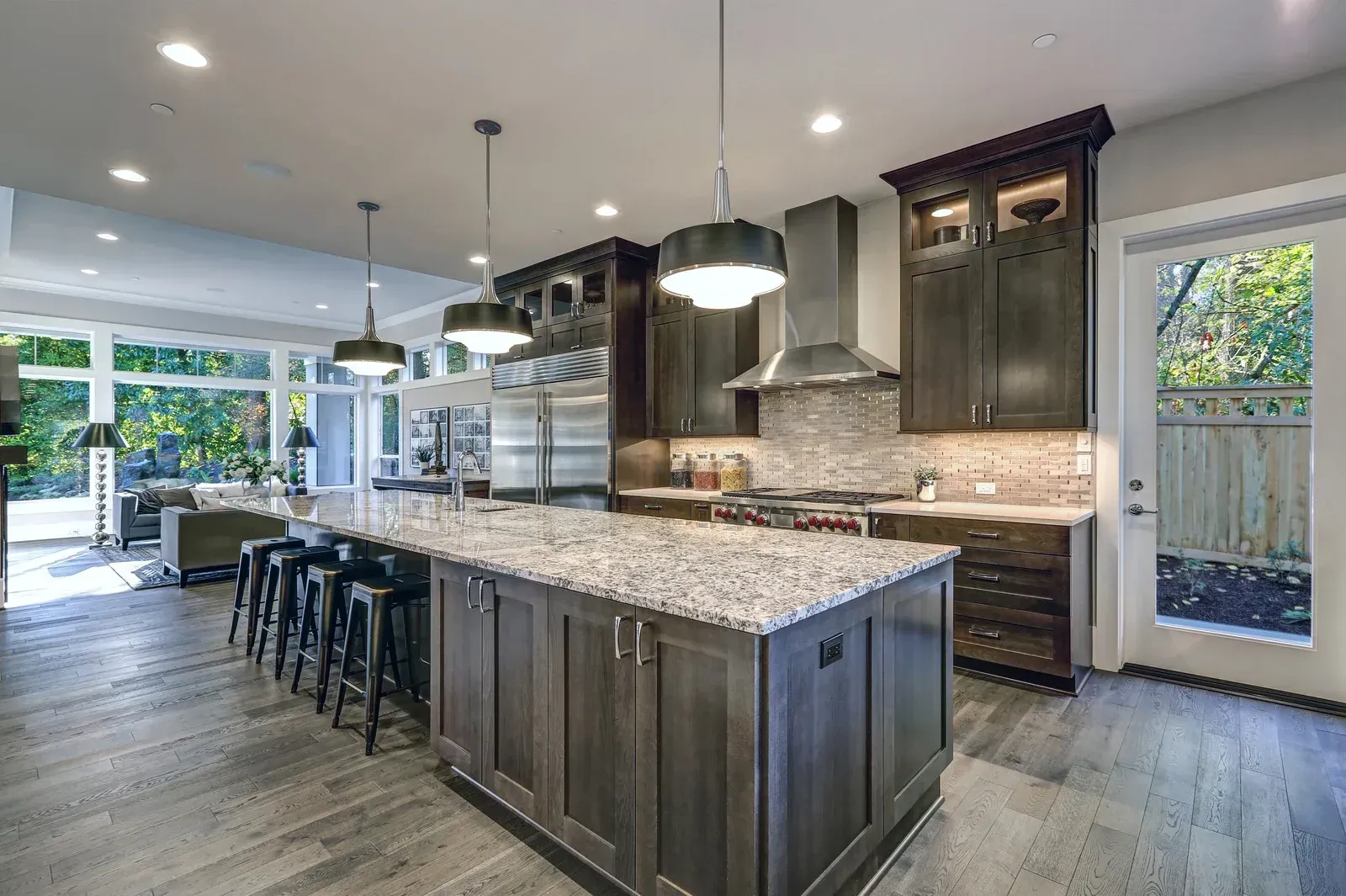 White kitchen cabinets with appliances and granite countertops. A person is visible.