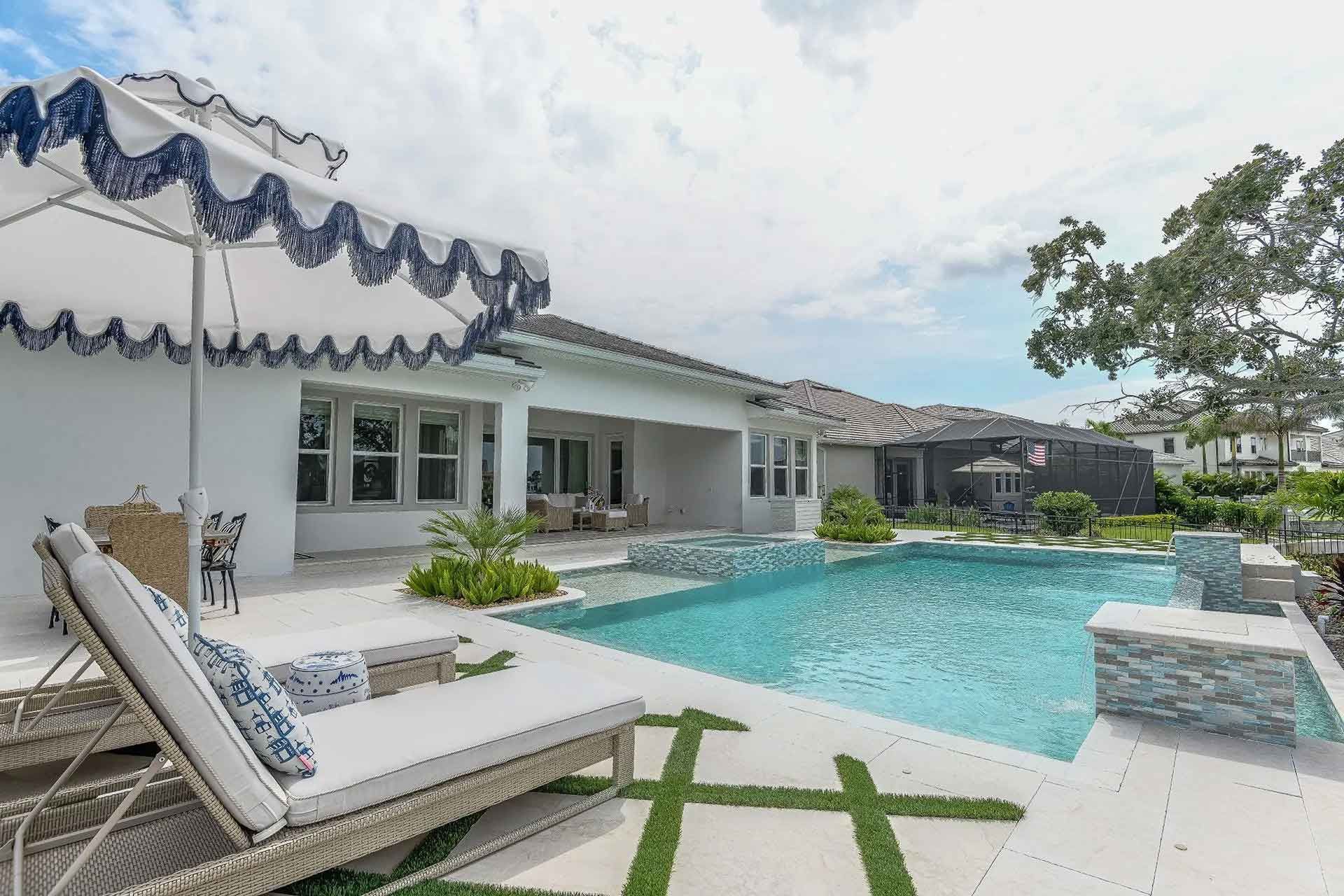 There is a large swimming pool in the backyard of a house.