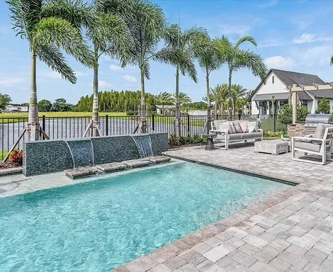 There is a large swimming pool with a waterfall in the middle of it.