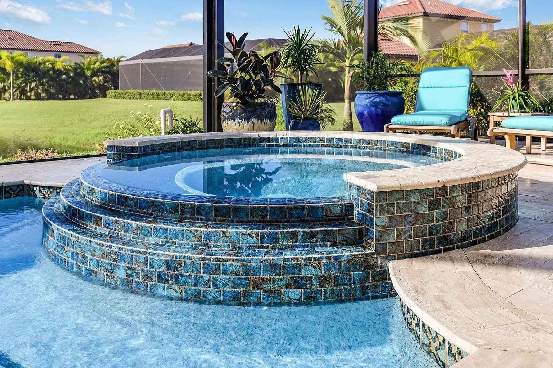 A large swimming pool with a hot tub in the middle of it.