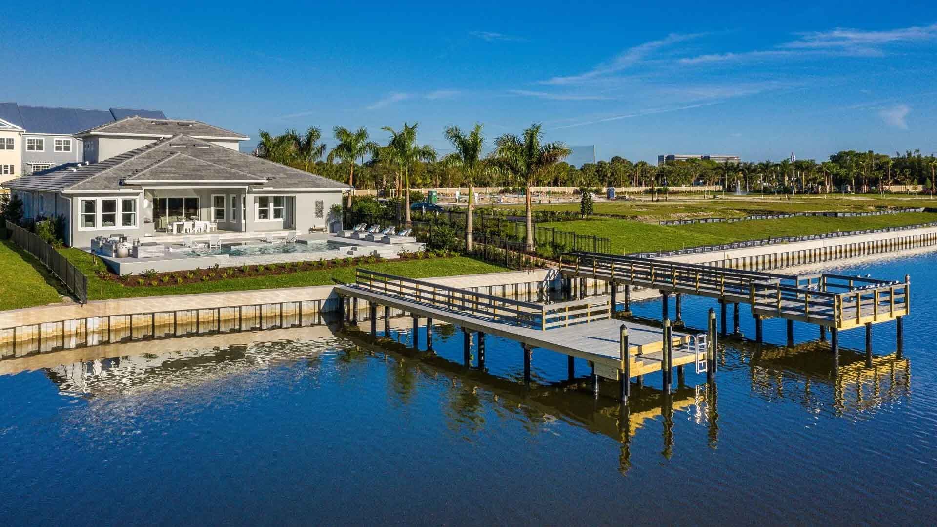 An aerial view of a house and a dock overlooking a body of water.