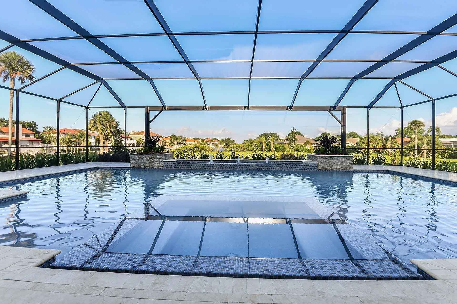 A large swimming pool with a screened in area surrounding it.