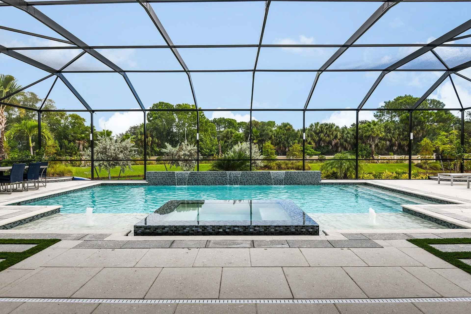 A large swimming pool with a screened in area in the backyard.