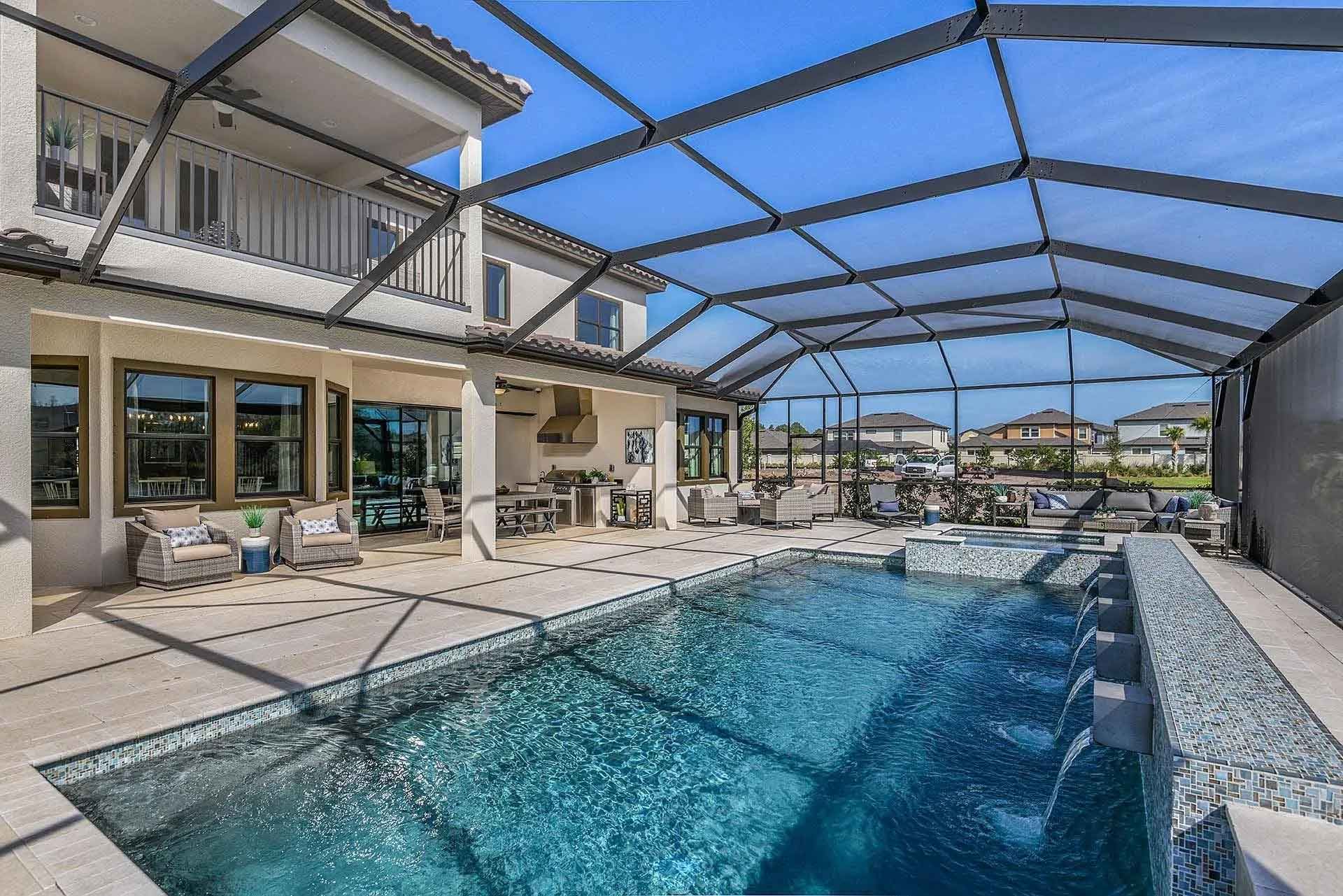 There is a large swimming pool in the backyard of a house.