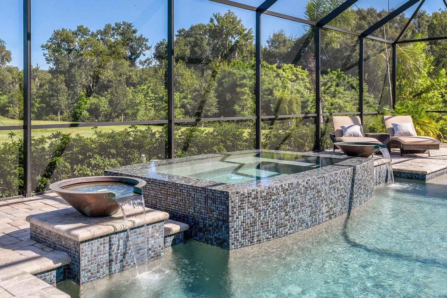 A large swimming pool with a hot tub in the middle of it.