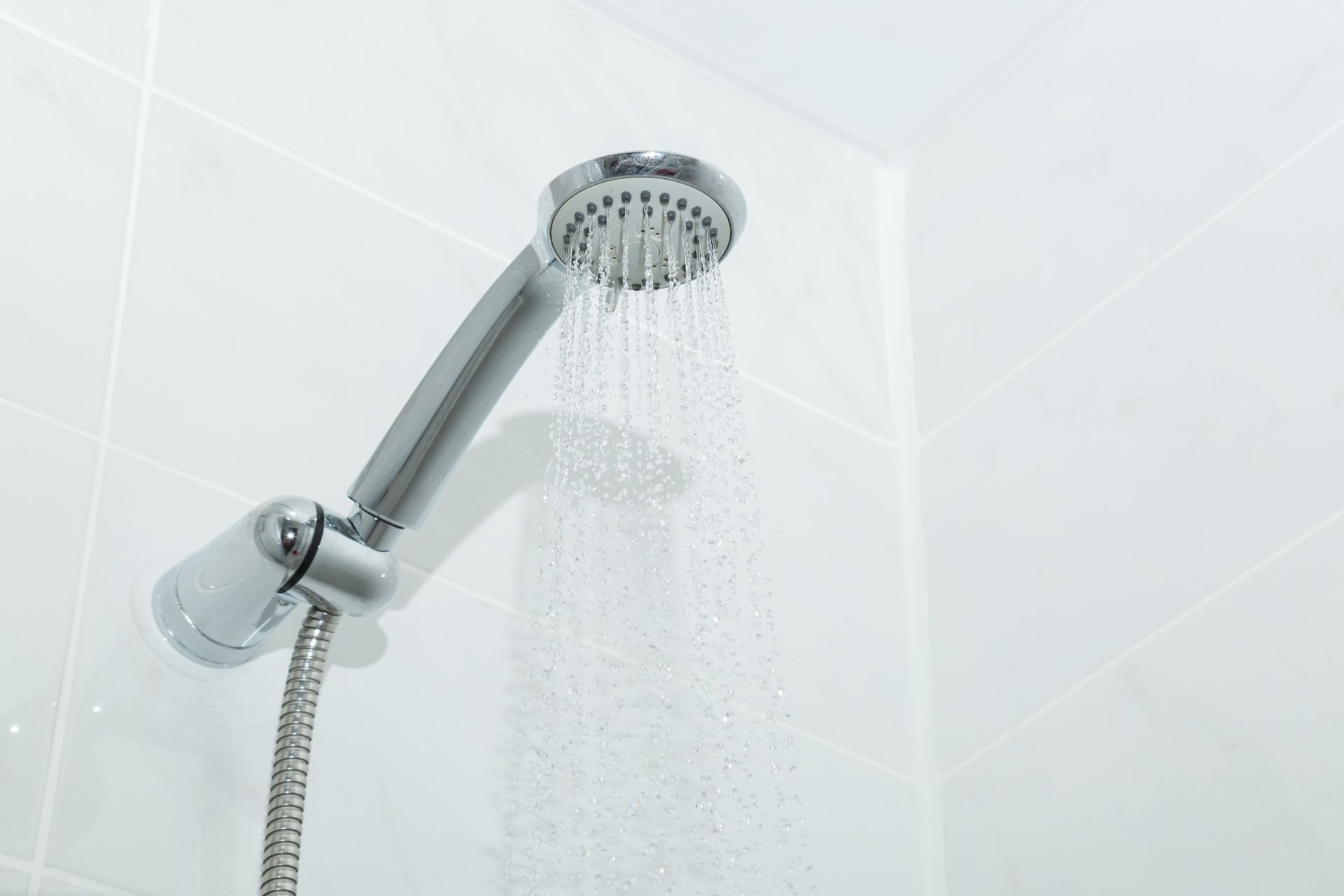 Un primer plano de un cabezal de ducha del que sale agua.
