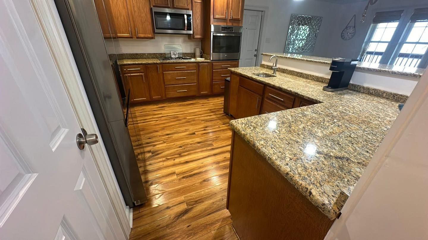 Kitchen with wood cabinets, granite countertops, and hardwood floors.