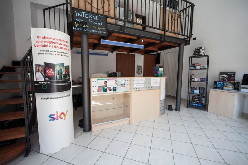 Lastre di vetro verticali di diverse altezze sono disposte in fila sotto un soffitto di lamiera ondulata.