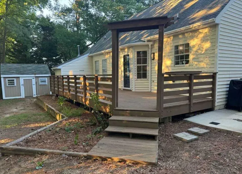 A house with a deck and stairs in front of it.