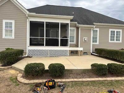 A screened in porch is being built on the side of a house.