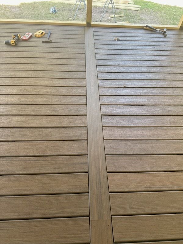 Brown composite deck with a central strip, tools scattered.