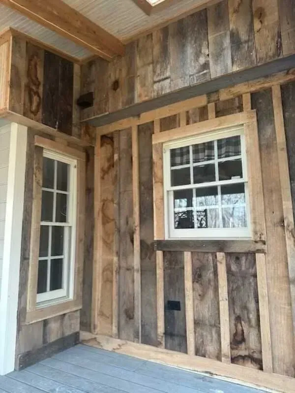 A wooden wall with two windows on it