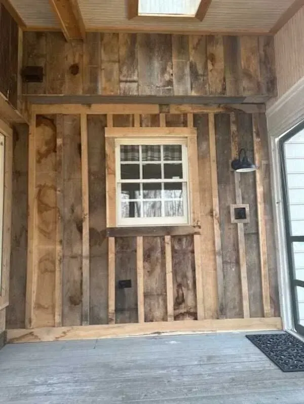 A room with a wooden wall and a window.