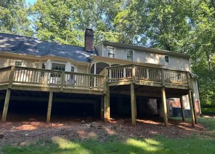 A large house with a large wooden deck in front of it.