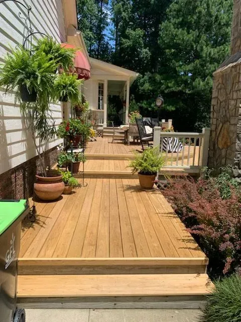 A wooden deck with steps leading to a house.