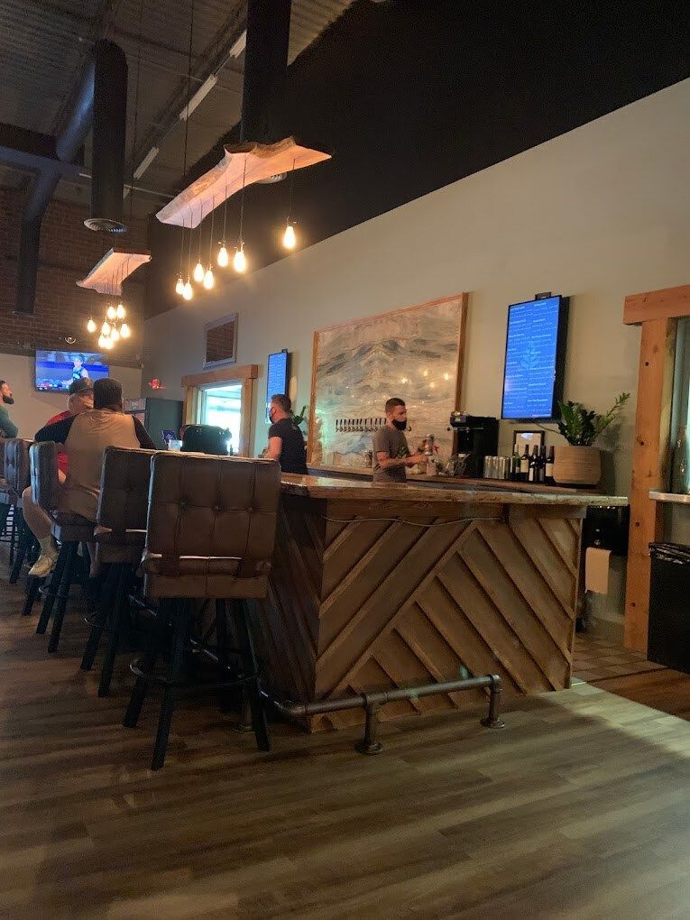 A group of people are sitting at a bar in a restaurant.
